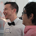 Thumbnail showing two former post-docs laughing and smiling at a UNC function