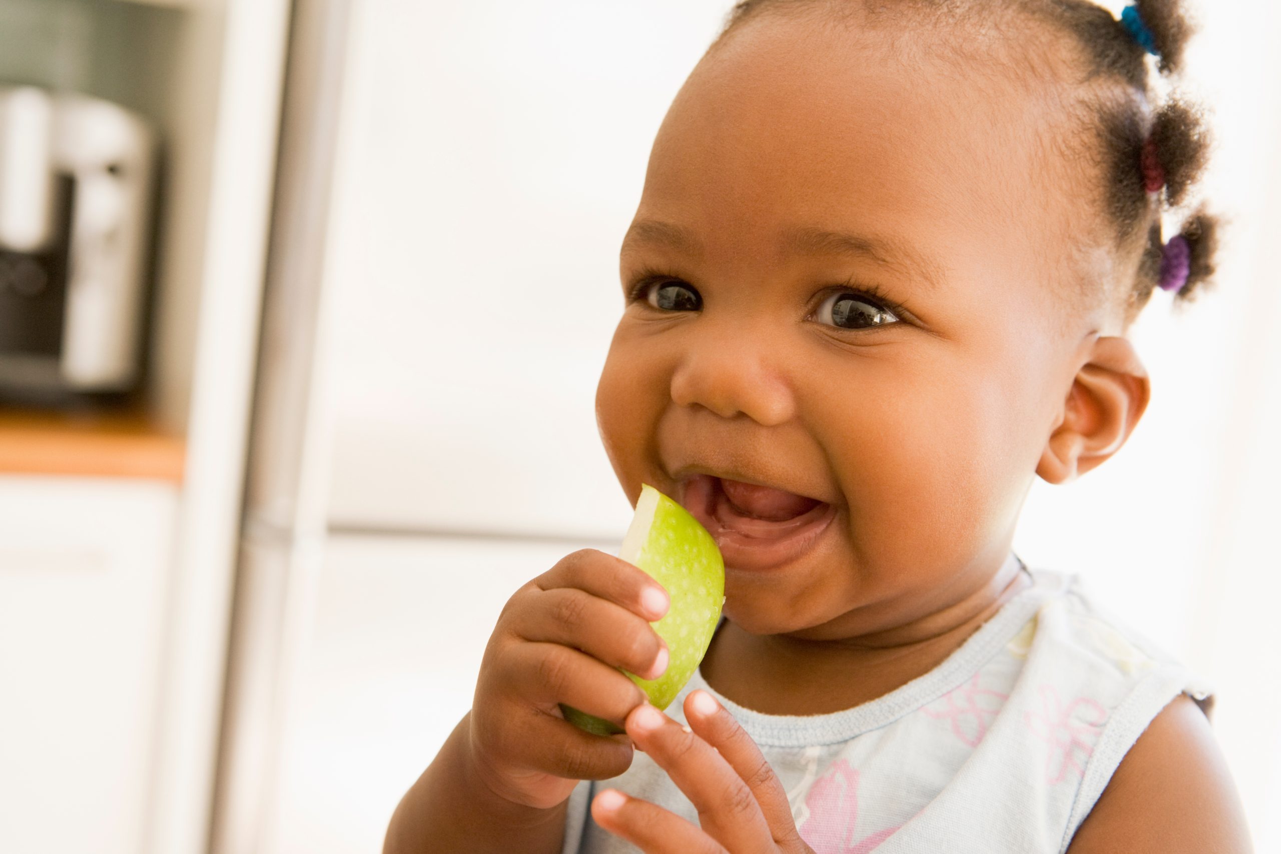 Young girl eating apple indoors