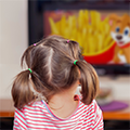 Thumbnail image: back of young child's head with TV in foreground showing french fries and a cartoon dog