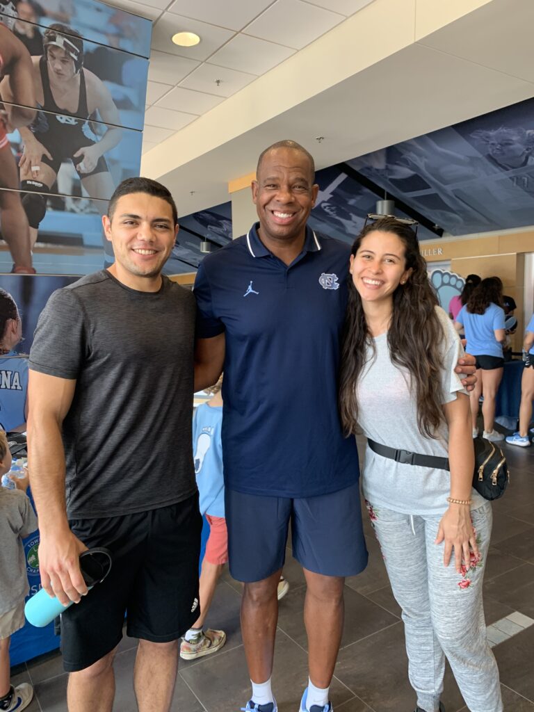 Jonathan Lara-Arevalo and wife Lorena posing with UNC basketball coach Hubert Davis